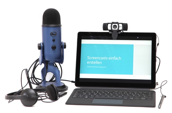 Foto: Ein Setup für Screencasts besteht aus einem Mikrofon, einem Headset, einer Webcam und einem Tablet mit Tastatur, auf dem "Screencasts einfach erstellen" angezeigt wird.