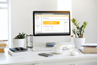 Foto: Schreibtisch mit Monitor, auf der die Bedienoberfläche der Lernplattform Moodle zu sehen ist.
